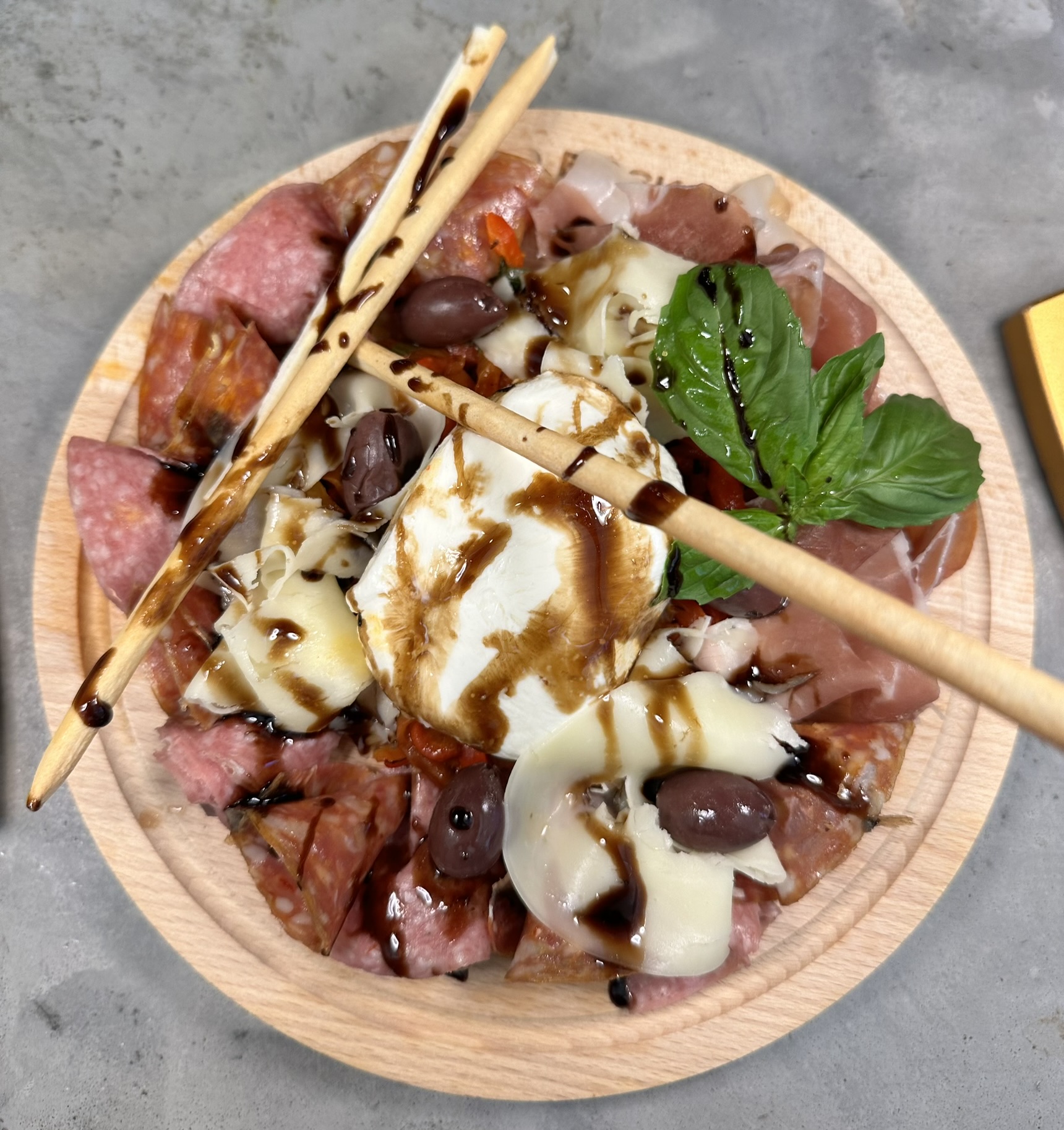 Cold antipasto board — cured meats, burrata, olives and roasted peppers with breadsticks