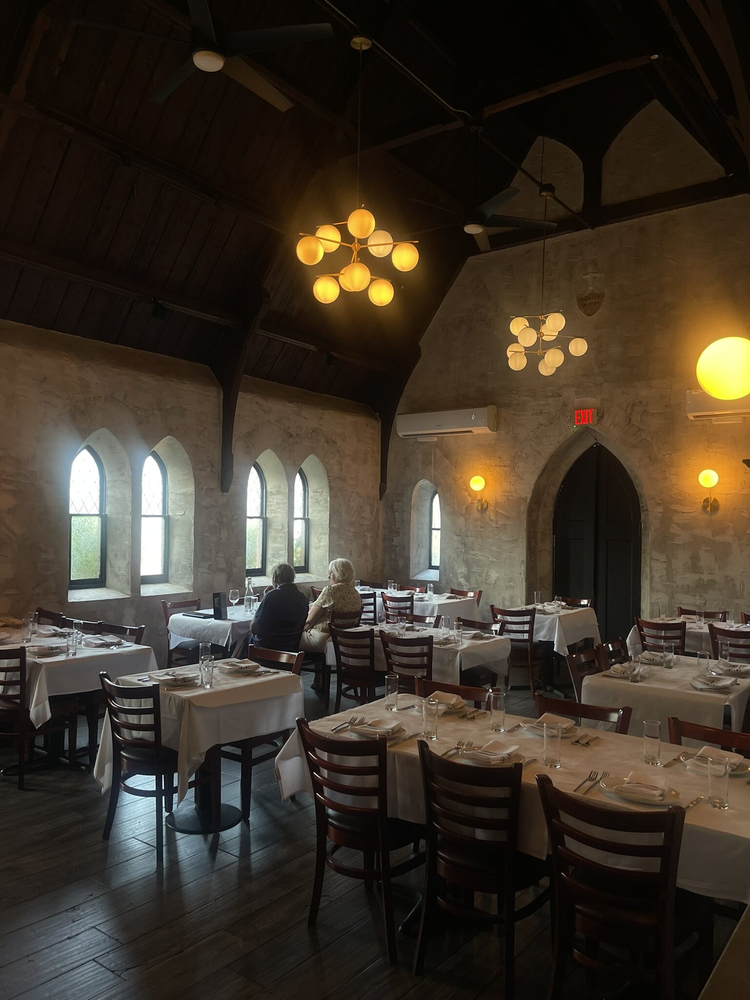 Globe chandeliers above set tables in the Church Room